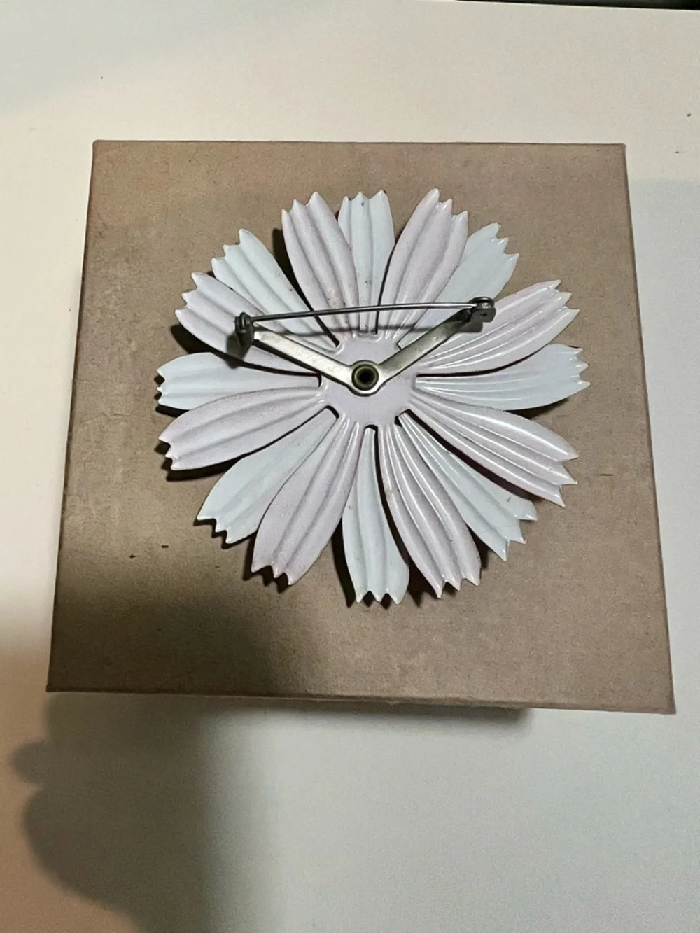 1960s enamel brooch with red and white petals and blue dome center.